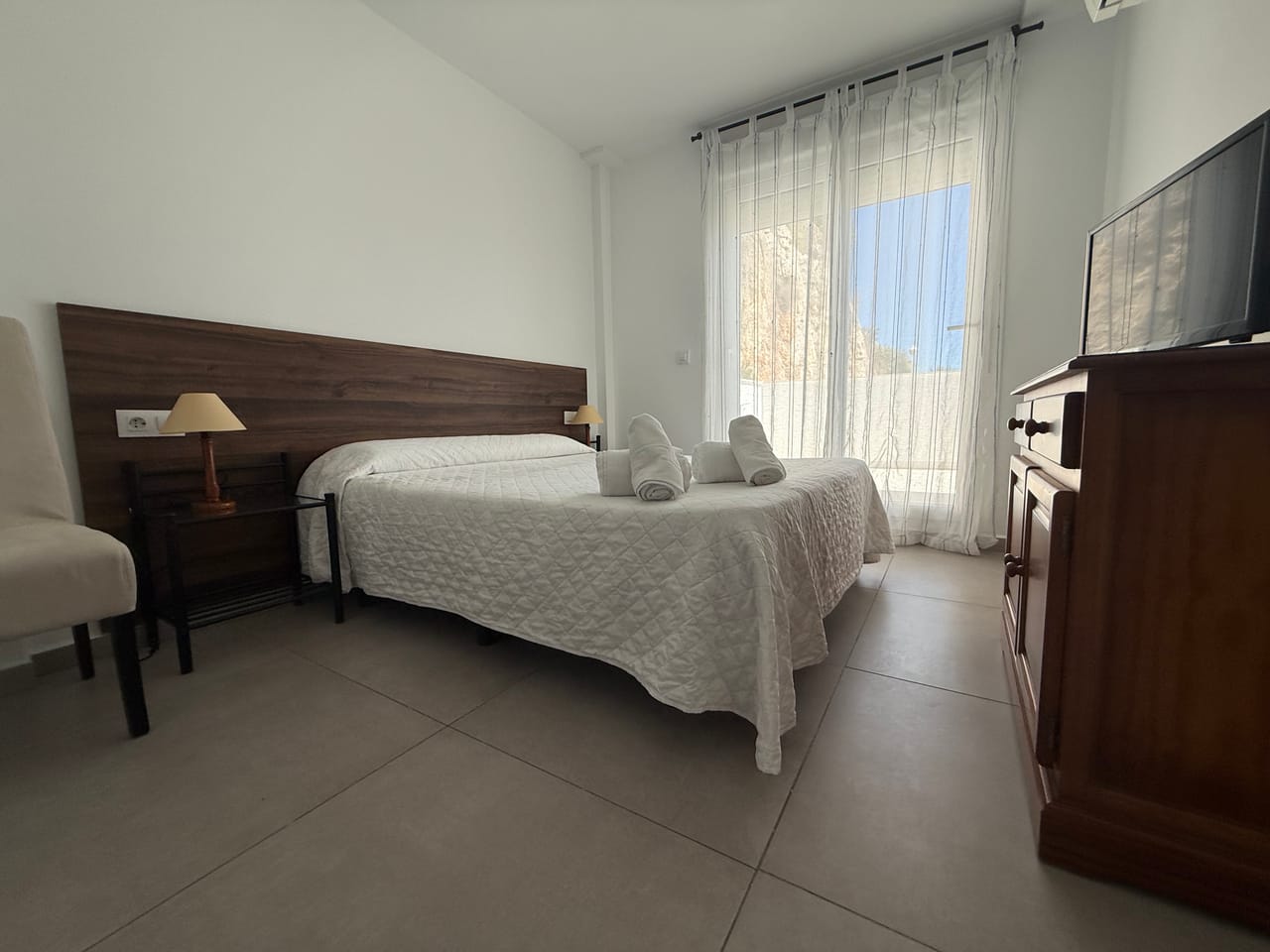 Habitación luminosa con sol entrando por la terraza