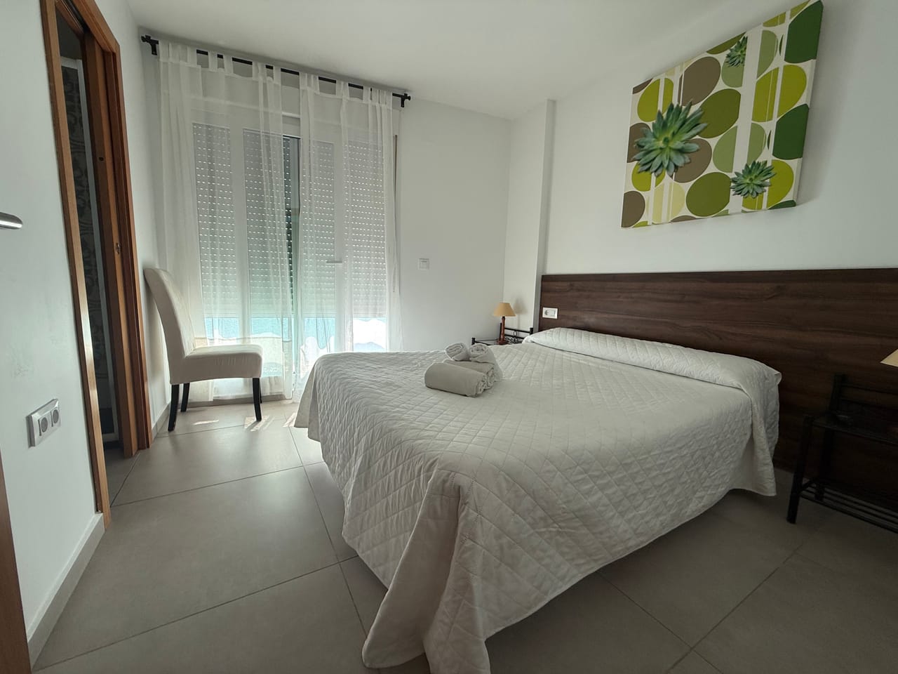Habitación con cuadro botánico verde, texturas naturales