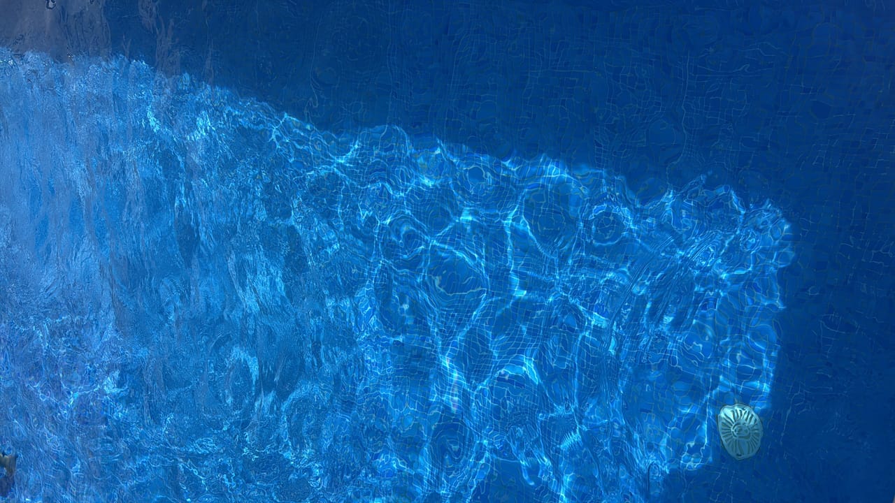 Textura abstracta de agua con reflejos de luz en la piscina
